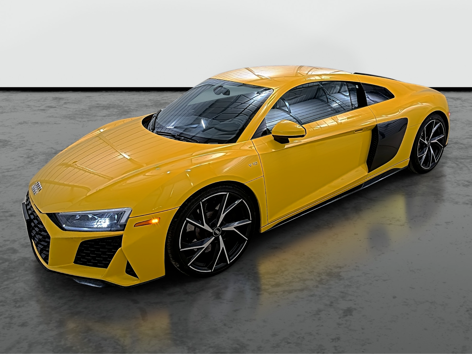 Yellow luxury sports car photographed in a professional studio from front side angle with clean background for automotive dealership listing.